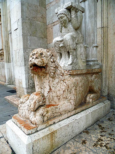 tl_files/Fotos/Anna-Landsberg/Ferrara-Kathedrale-Hauptportal-linker-Loewe-mit-Traegerfigur-IMG-6352.jpg