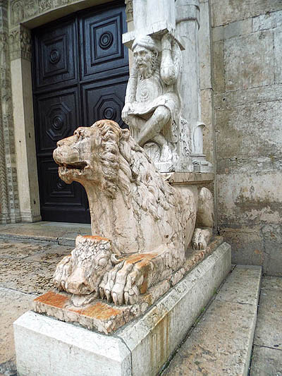 tl_files/Fotos/Anna-Landsberg/Ferrara-Kathedrale-Hauptportal-rechter-Loewe-mit-Traegerfigur-IMG-6354.jpg